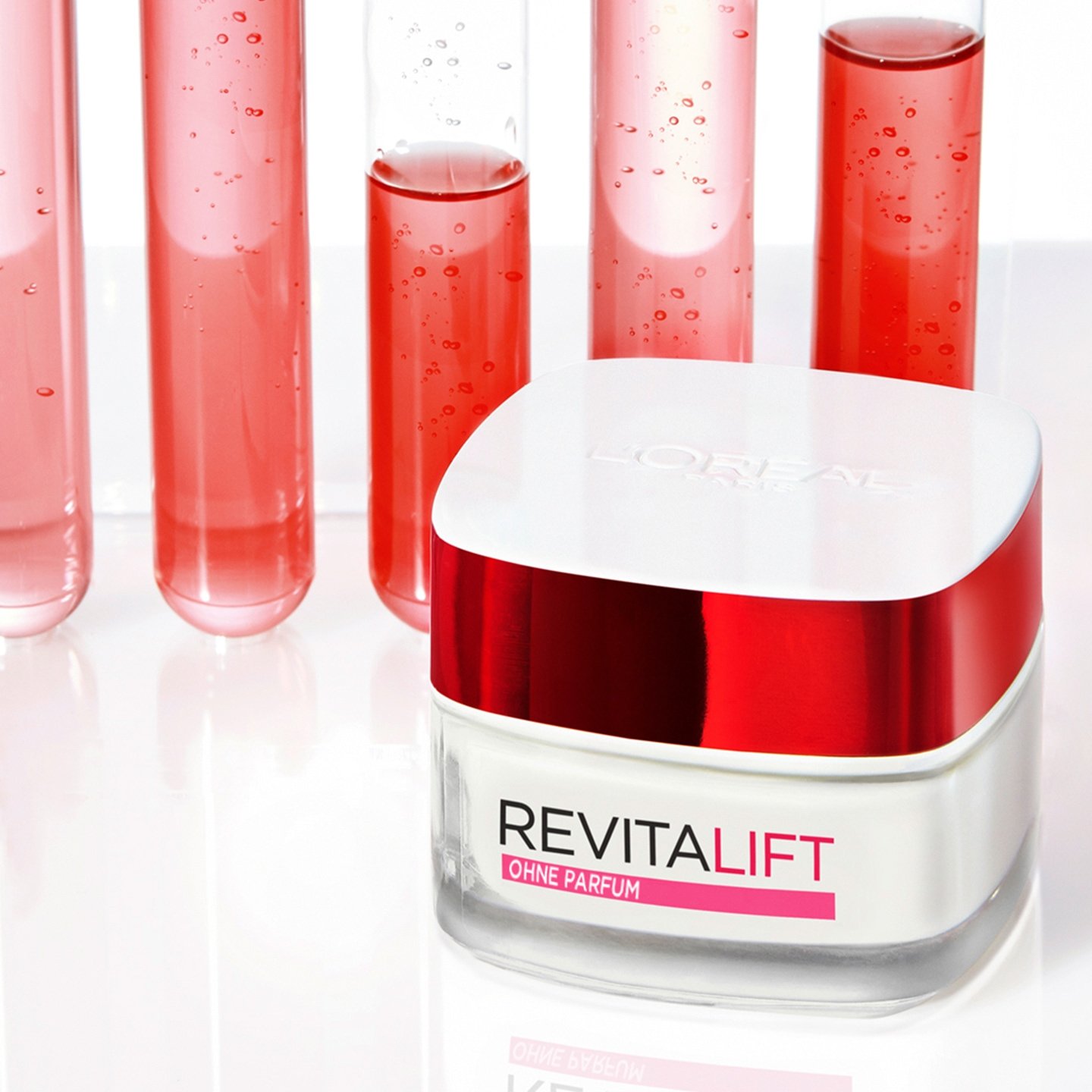 Reagenzgläser mit roter Flüssigkeit stehen hinter einer Dose Revitalift Klassik Feuchtigkeitspflege ohne Pafüm